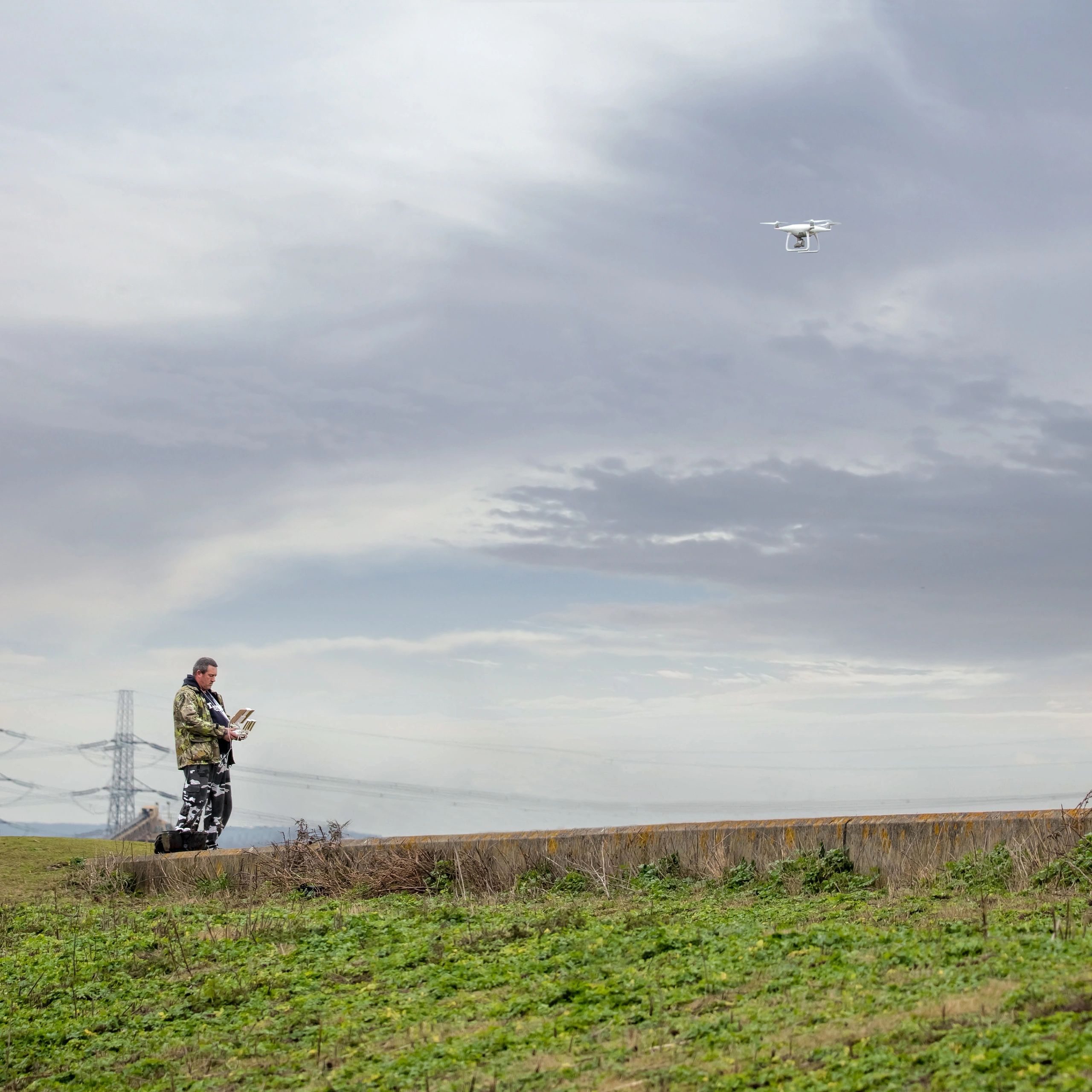 Drone operator in field with remote control